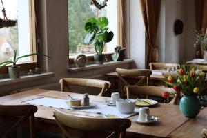 a dining room with tables and chairs and windows at Hotel Carolaruh in Bad Elster