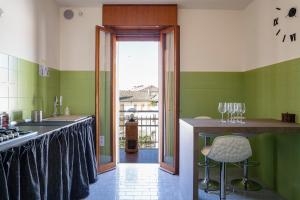 una cocina con paredes verdes y una barra con copas de vino en Il Centrale, en Conegliano