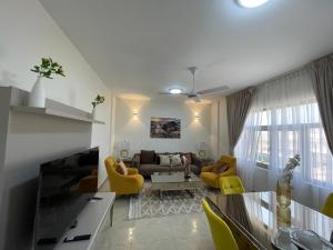 un soggiorno con divano e sedie gialle di WAAFI LA CORNICHE RESIDENCE a Gibuti