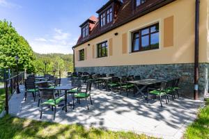 a patio with tables and chairs in front of a building at SPA Pod Javory in Nejdek