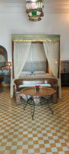a bedroom with a bed and a table in a room at Riad Ifoulki in Marrakesh