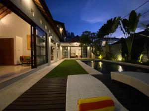 an exterior view of a house with a swimming pool at night at Spacious Villa in Seminyak Top Location in Seminyak