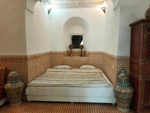 1 dormitorio con 1 cama y 2 jarrones en Riad Ifoulki, en Marrakech