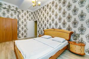 Deluxe Apartment 128/34 في باكو: غرفة نوم بسرير في غرفة مع ورق جدران