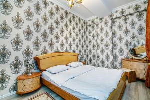 - une chambre avec un lit et du papier peint floral dans l'établissement Deluxe Apartment 128/34, à Baku