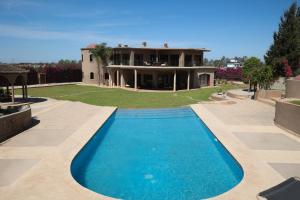 una casa con piscina di fronte a una casa di Villa Tizra - guest house a AÃ¯n el Ksob