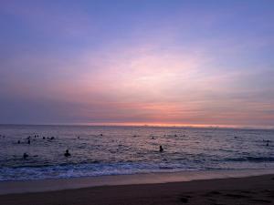 a group of people in the ocean at sunset at CASA Camping House in Tuy Hoa