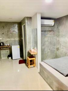 um quarto com uma cama e um frigorífico em Cactus Resort em Ko Larn