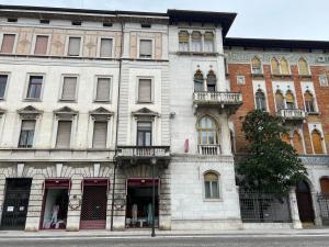 een groot wit gebouw aan de kant van een straat bij Garden View boutique apartments in Gorizia