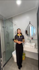 Eine Frau steht in einem Badezimmer neben einer Toilette. in der Unterkunft CASA Camping House in Tuy Hoa