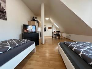 two beds in a room with a tv and a table at Möblierte Wohnung mit ruhiger Terrasse in bester Lage für Feriengäste und beruflich Reisende in Ottersberg