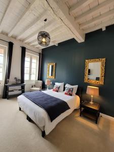 um quarto com uma cama grande e uma parede azul em Pavillon des Millésimes em Lussac