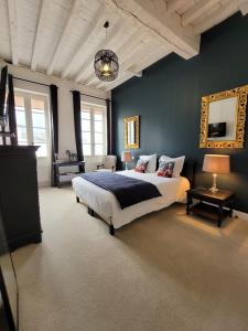 um quarto com uma cama grande e paredes azuis em Pavillon des Millésimes em Lussac
