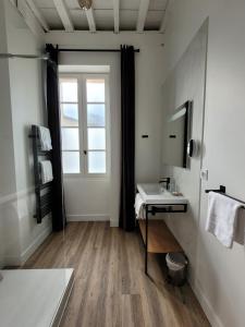 uma casa de banho com um lavatório e uma janela em Pavillon des Millésimes em Lussac