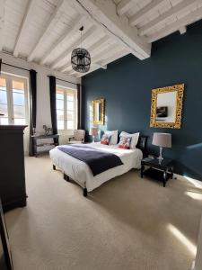 LussacにあるPavillon des Millésimesの青い壁のベッドルーム1室(大型ベッド1台付)