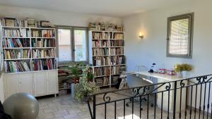 um quarto com várias prateleiras de livros cheias de livros em Villa Saint Roch em Malaucène