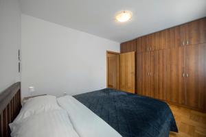 a bedroom with a large bed and wooden cabinets at Apartment Marci with parking in Zagreb