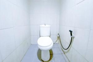 een badkamer met een toilet met een slang bij 4N Residence RedPartner in Jakarta