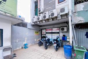 twee motorfietsen geparkeerd buiten een gebouw met airconditioners bij 4N Residence RedPartner in Jakarta