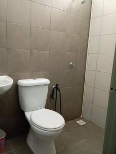 a bathroom with a white toilet and a sink at D'Alessa Homestay in Alor Setar