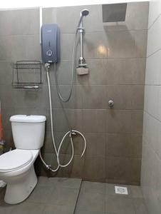 a bathroom with a toilet and a phone on the wall at D'Alessa Homestay in Alor Setar