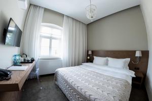 a bedroom with a bed and a desk and a window at Hotel Jakubus in Wilków