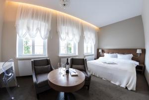 Hotel Jakubus في Wilków: غرفة فندقية بسرير وطاولة وكراسي