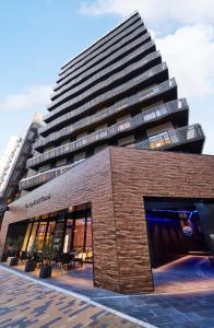 a tall building in front of a building at The Royal Park Canvas - Kobe Sannomiya in Kobe