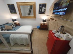 um pequeno quarto com uma cama e um espelho em Corte del Dattilo nel Borgo Antico em Bari