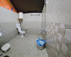 a small bathroom with a toilet and a shower at Hipostel Bir - Stay and Cafe in Bīr