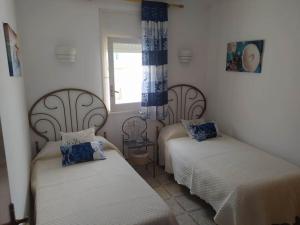 a room with two beds and a window at Amplio apartamento Blanes in Blanes