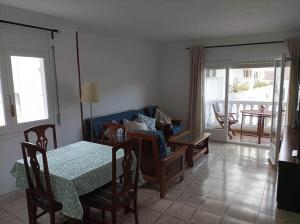 a living room with a table and a couch at Amplio apartamento Blanes in Blanes