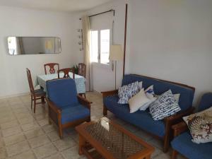a living room with a blue couch and chairs at Amplio apartamento Blanes in Blanes