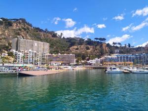 a harbor with boats in the water and a beach at Amplio apartamento Blanes in Blanes