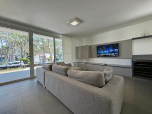 a living room with a couch and a flat screen tv at Villa Sunshine in Lignano Sabbiadoro