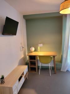 a room with a desk and a yellow chair at Twenty Business Flats Jouy-en-Josas in Jouy-en-Josas