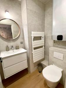 La salle de bains est pourvue de toilettes, d'un lavabo et d'un miroir. dans l'établissement Appartement 3 chambres Hyper centre Bayonne, à Bayonne