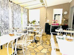 a restaurant with white tables and white chairs at Hotel Italia in Tours