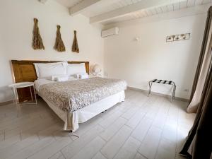 ein weißes Schlafzimmer mit einem Bett und Holzboden in der Unterkunft San Michele Luxury Rooms in Matera