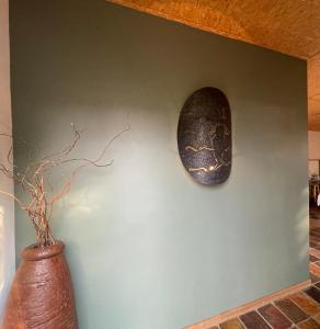 a wall with a shield and a vase on a wall at Aloegrove Safari Lodge in Otjiwarongo