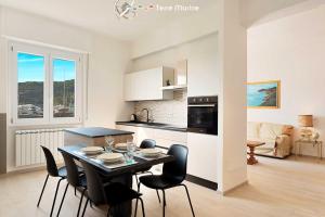uma cozinha e sala de jantar com mesa e cadeiras em Giuly House, Terre Marine em Le Grazie