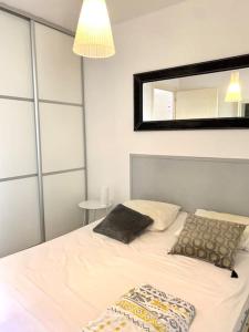 - une chambre avec un lit et un miroir mural dans l'établissement Appartement centre ville - 4p, à LʼÎle-Rousse