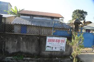een bord aan de zijkant van een muur bij Tharu COOP Homestay in Sauraha, Kathar :Chitwan in Sauraha