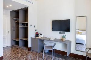 een kamer met een bureau met een spiegel en een bed bij Palazzo Costarelli - Bed and Breakfast in Catania