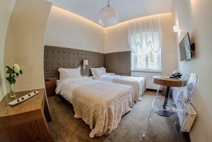 ein Hotelzimmer mit 2 Betten und einem Tisch in der Unterkunft Hotel Jakubus in Wilków