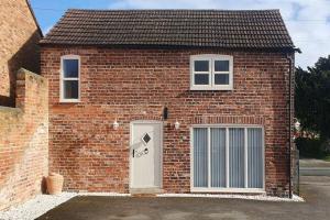 a red brick house with a white door at Country Cottage Barn Conversion in Pollington