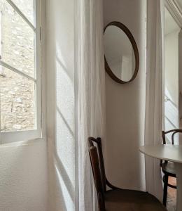 Habitación con mesa, espejo y ventana en A CASA ROSSA L'Olivier, en Saint-Paul-de-Vence