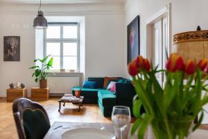 a living room with a couch and a table with flowers at Apartament Rynek Główny 7 in Krakow