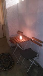 una vela sentada en un banco junto a un taburete en happy home, en Bucarest