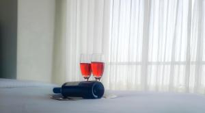 ネゴンボにあるSea Waveのベッドの上に座るワイン2杯